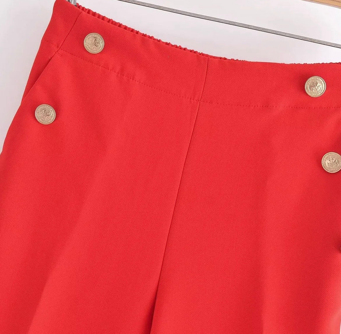 Pantalones rojos con botones dorados